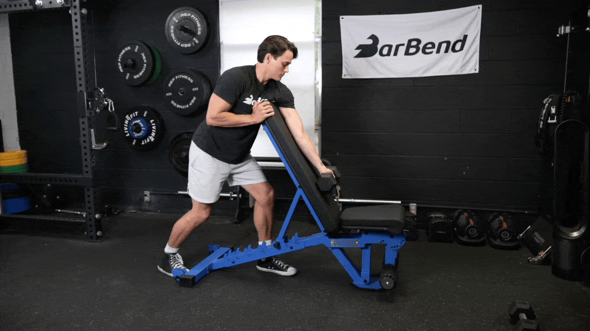BarBend's Jake Herod performing the arm-over bench preacher curl exercise.