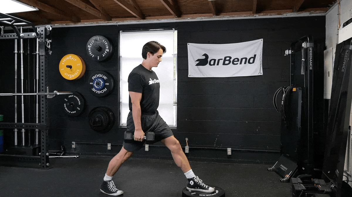 BarBend's Jake Herod performing the Front-Foot-Elevated Split Squat in the BarBend gym.