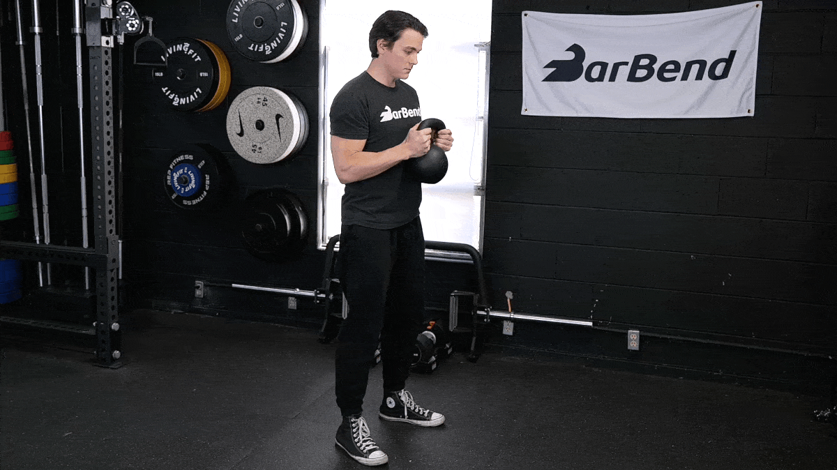 BarBend's Jake Herod performing the goblet squat exercise with a kettlebell.