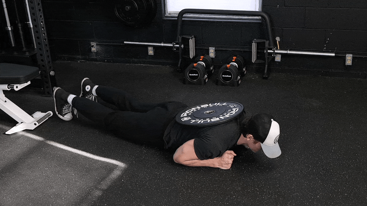 BarBend's Jake Herod performing the weighted plank.