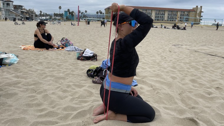 Our BarBend Tester warms up triceps with one of the Fringe Sport Resistance Bands.